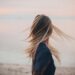 Blonde woman enjoying a serene sunset by the beach, capturing the essence of tranquility.